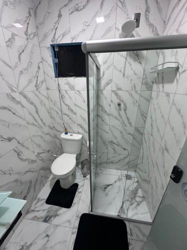 a white bathroom with a toilet and a shower at House in Itacaré in Itacaré