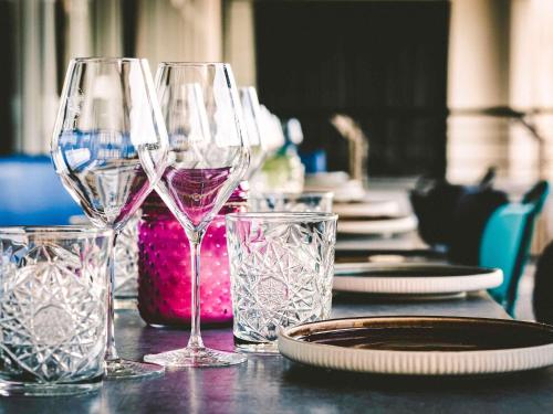 a table with wine glasses and plates on it at Novotel Bordeaux Centre Ville in Bordeaux