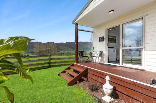 a wooden deck with a bench on the side of a house at Matamata Lodge in Matamata