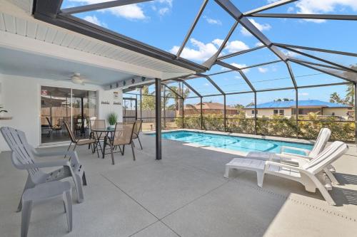 a patio with a pool and chairs and a table at Whole cozy house for group of 4 in Cape Coral