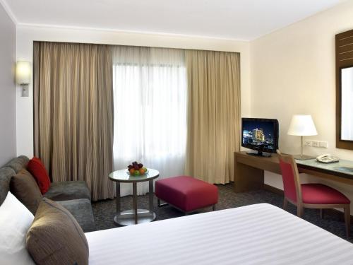 a hotel room with a bed and a desk at Novotel Bangkok on Siam Square in Bangkok