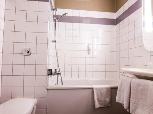 a bathroom with a tub and a toilet and a sink at ibis Colmar Est - Hotel Restaurant en Alsace in Colmar