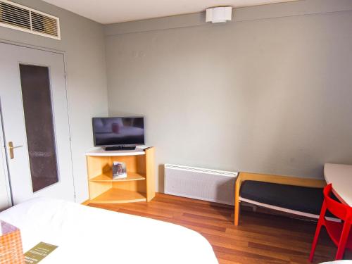 a bedroom with a bed and a tv on a table at ibis Colmar Est - Hotel Restaurant en Alsace in Colmar