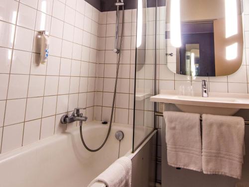 a bathroom with a shower and a sink and a tub at ibis Colmar Est - Hotel Restaurant en Alsace in Colmar