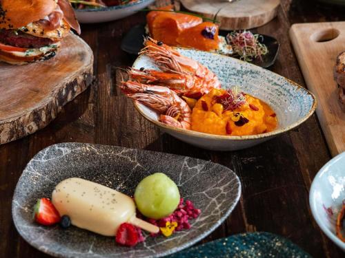 Una mesa cubierta con platos de comida y un sándwich. en Mercure Paris Val de Fontenay, en Fontenay-sous-Bois