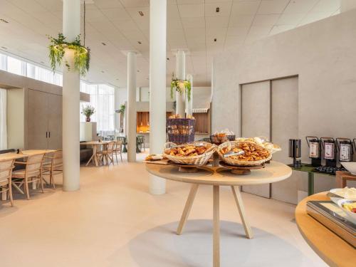 a table with two baskets of food on top of it at Novotel Brugge Centrum in Bruges