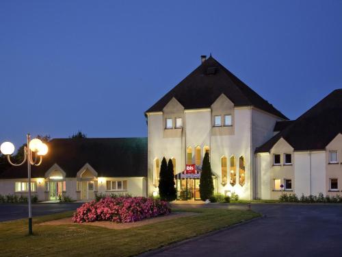 a large white building with a black roof at Ibis Château-Thierry in Essômes-sur-Marne