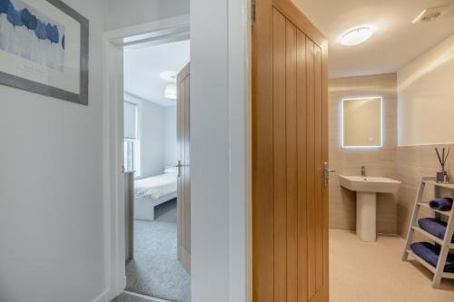 a bathroom with a sink and a door to a bathroom with a sink at Hide Away in Berwick-Upon-Tweed