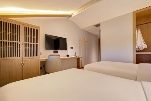 a hotel room with two beds and a television at Floral Hotel Yunkexuan in Datong