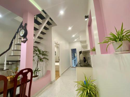 a hallway with pink and white walls and potted plants at Homestay NAD nguyên căn tại Phan Thiết in Ấp Sung Xuân