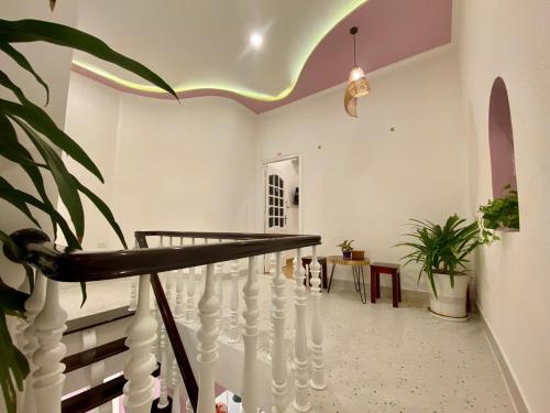 a hallway with white stairs and a potted plant at Homestay NAD nguyên căn tại Phan Thiết in Ấp Sung Xuân