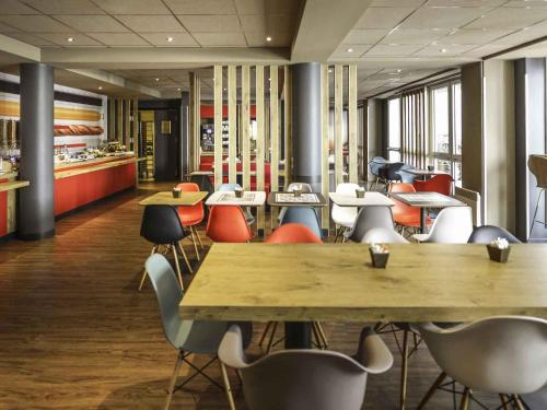 ein Restaurant mit Tischen und Stühlen in einer Cafeteria in der Unterkunft ibis Château de Fontainebleau in Fontainebleau