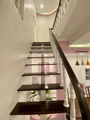a staircase in a house with black and pink walls at Homestay NAD nguyên căn tại Phan Thiết in Ấp Sung Xuân