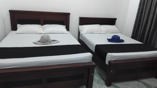two beds with hats on them in a room at VILLA AAA WELIGAMA in Weligama