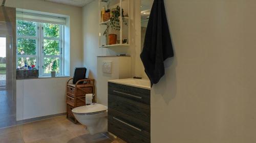 a bathroom with a toilet and a window at Renovated Farmhouse With Starry Sky Views in Barrit
