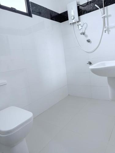 a white bathroom with a toilet and a sink at VILLA AAA WELIGAMA in Weligama