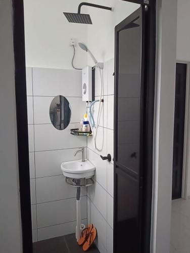 a bathroom with a sink and a mirror at Homestay AGM in Mersing