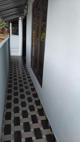 a hallway with a checkered floor and windows at VILLA AAA WELIGAMA in Weligama