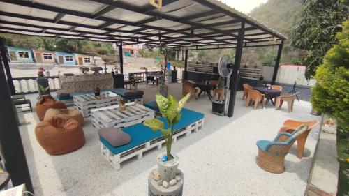 a patio with couches and tables and chairs at Stay Sukoonn Off Beat Staycation in Mohan Chatti