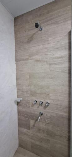 a shower with two faucets in a bathroom at Vela Villa Apart in Villa Ángela