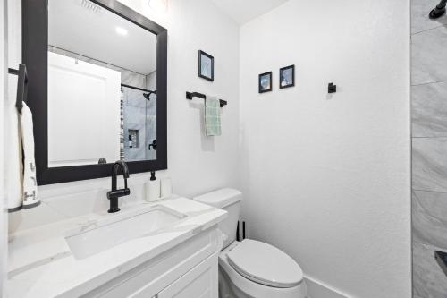 a white bathroom with a sink and a mirror at 4BR Modern Getaway by Lackland & SeaWorld in San Antonio