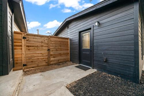 a garage with a black door and a wooden fence at 4BR Modern Getaway by Lackland & SeaWorld in San Antonio