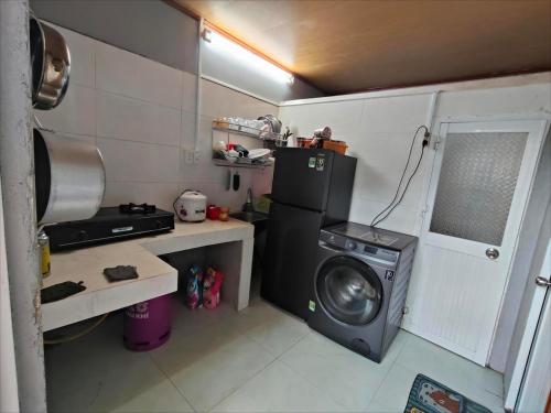 a small kitchen with a washing machine and a washer at Cay Bang Homestay in Long Hai