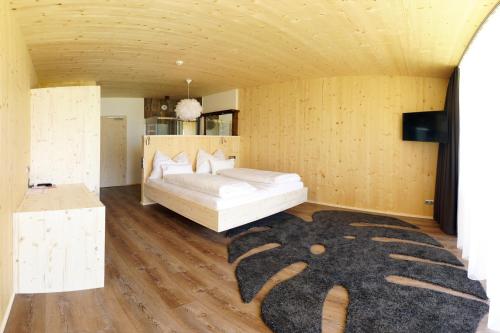 a bedroom with a white bed and a black rug at Wildauers Haidenhof STAY & SLEEP in Lienz