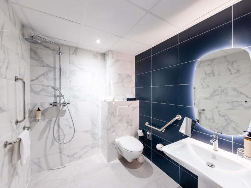 a bathroom with a toilet and a shower and a sink at Mercure Nancy Centre Place Stanislas in Nancy