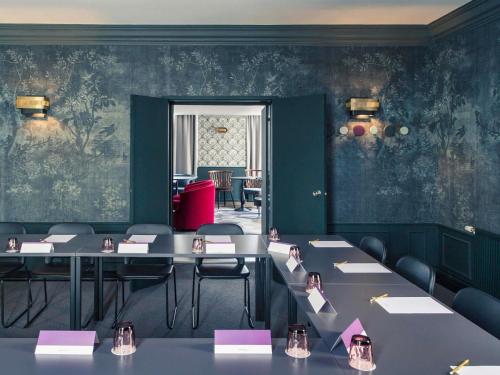 a dining room with tables and chairs and green walls at Mercure Nancy Centre Place Stanislas in Nancy
