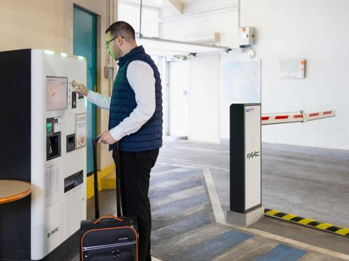 a man is standing in front of a machine at Mercure Nancy Centre Place Stanislas in Nancy