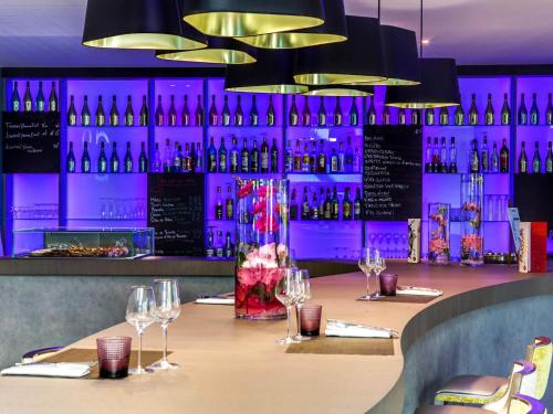 a table in a restaurant with wine glasses at Novotel Orléans Saint Jean de Braye in Saint-Jean-de-Braye
