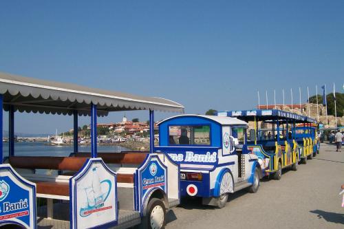 Un pequeño tren está estacionado junto al agua. en Complex Apolon, en Nesebar