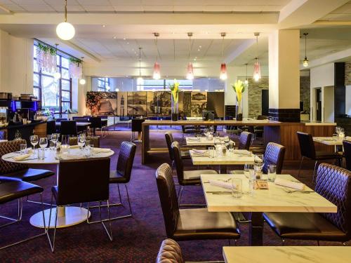 a dining room with tables and chairs and a restaurant at Novotel Birmingham Centre in Birmingham