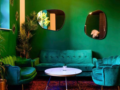 a green room with a couch and a table at Novotel Birmingham Centre in Birmingham