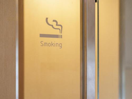 an elevator door with the smoking sign on it at Nishitetsu Resort Inn Naha in Naha