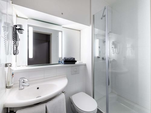 a bathroom with a sink and a toilet and a shower at ibis Mainz City in Mainz