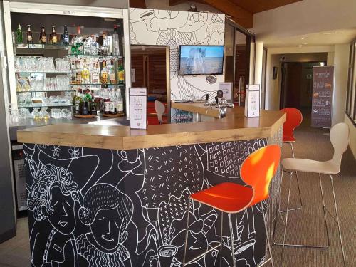 a bar with a painting on the wall at Ibis Angoulême Nord in Champniers