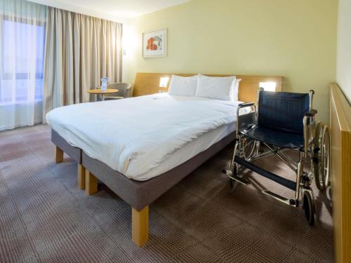 a hotel room with a bed and a wheelchair at Novotel Southampton in Southampton