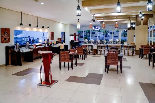 a restaurant with tables and chairs and a bar at LAMORA Sagan Yogyakarta - formerly H Boutique Yogyakarta in Yogyakarta