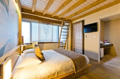 - une chambre avec un lit et une échelle dans l'établissement La Croix de Savoie & Spa, aux Carroz d'Arâches