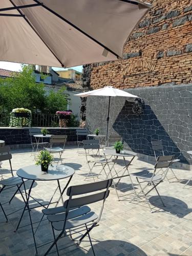 a patio with tables and chairs and an umbrella at Al Punto Giusto in Catania