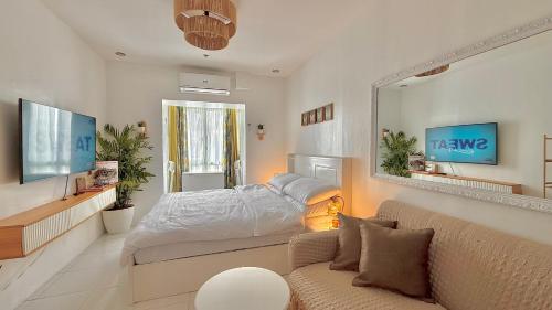 a bedroom with a bed and a couch and a mirror at Serene Haven with Skyline View in Sampong