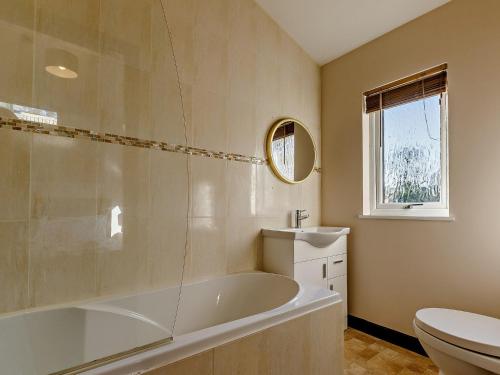 a bathroom with a tub and a toilet and a sink at 2 Bed in Sidmouth 91118 in Ottery Saint Mary