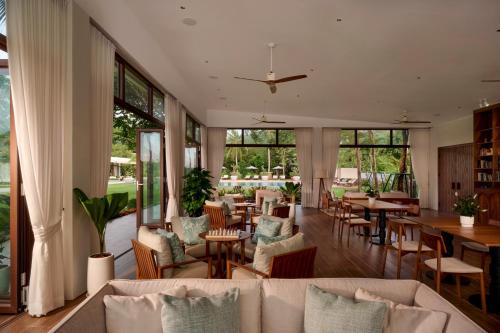 a living room with couches and tables and windows at Samanea Beach Resort & Spa in Kep
