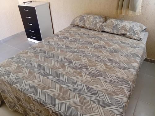 a bed in a room with a dresser and a bed sidx sidx at Pousada Araújo em Paraty in Paraty