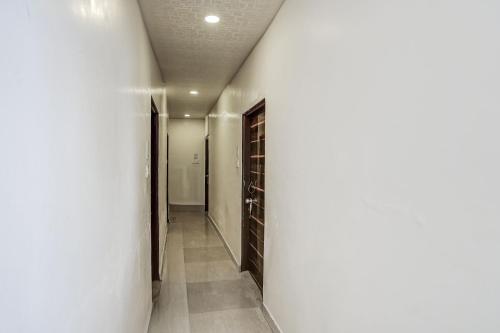 a hallway with white walls and a door to a room at HOTEL O REGAL INN in Dhantoli