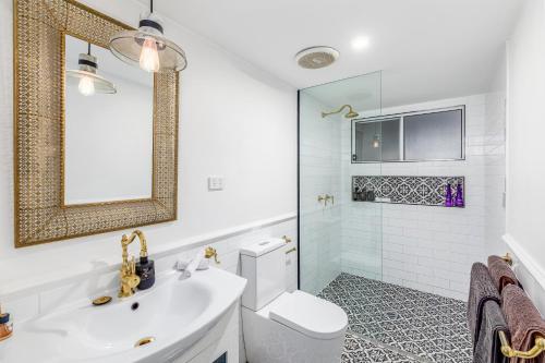 a bathroom with a sink and a toilet and a mirror at House of Mahalo Accommodation in Mapleton