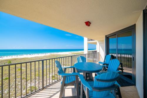 Un balcón con mesa y sillas y la playa. en Phoenix VII 7503 condo, en Orange Beach
