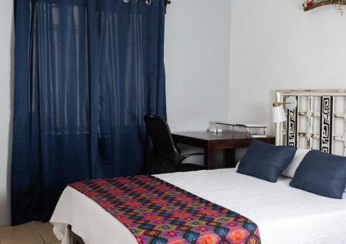a bedroom with a bed and a table with a desk at Genuina Inn, Tu Refugio Único, cerca de todo in Piedras Negras